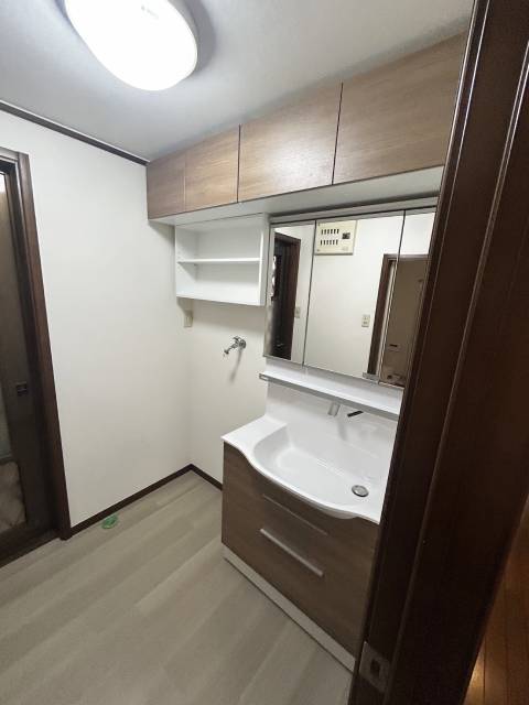 壁いっぱいの吊戸棚で収納力がアップした洗面所施工後イメージ１